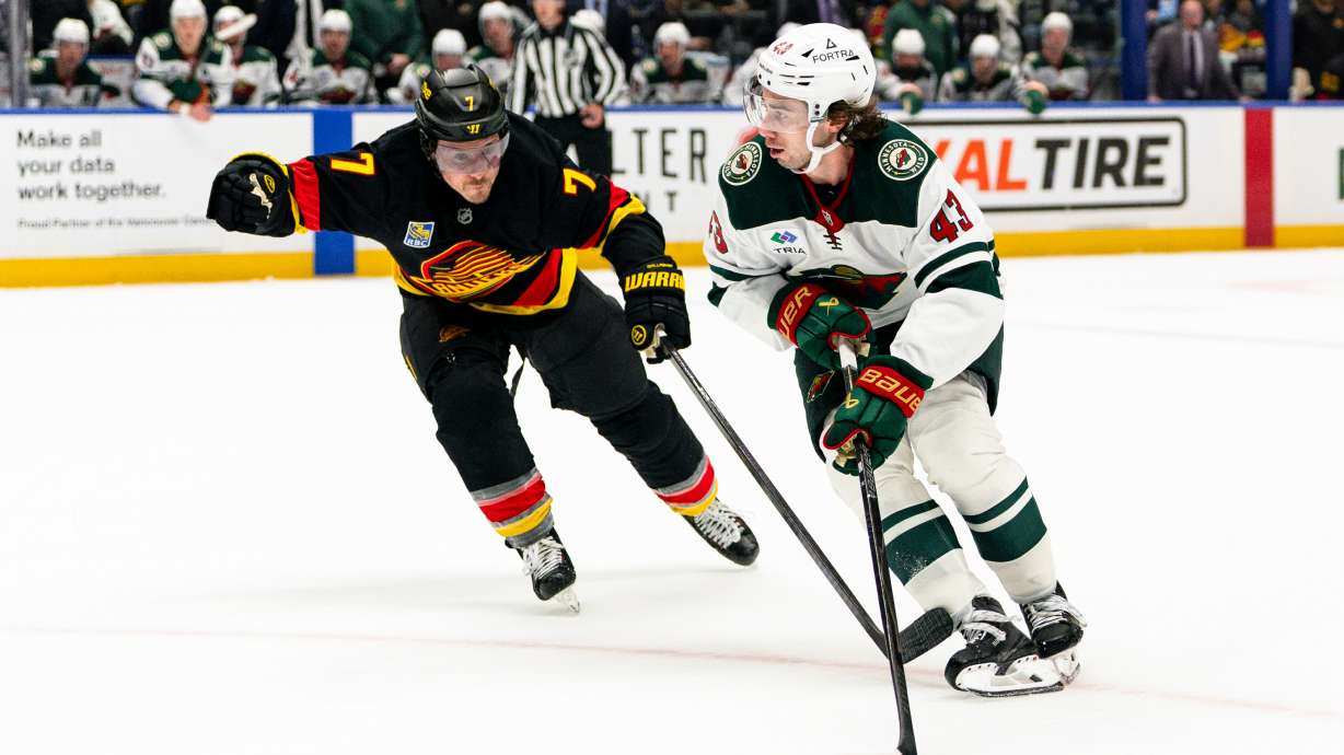 Minnesota Wild's Quinn Hughes (43) skates past Vancouver Canucks' Brendan Gallagher (7) during the second period of an NHL hockey game, in Vancouver, British Columbia, Sunday, Oct. 25, 2026.