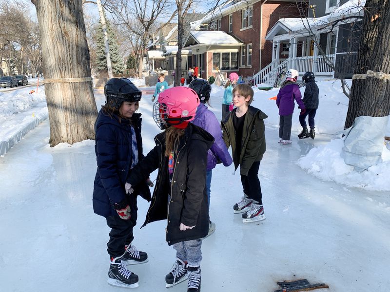 Children skate on a front-yard rink that stretches for four houses in Winnipeg, Manitoba, Canada, March 7, 2020.