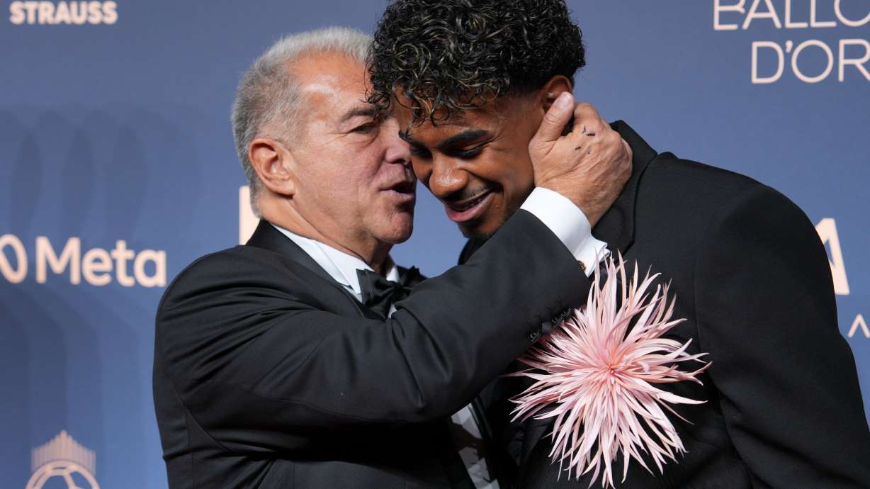 Lamine Yamal of Spain is hugged by president of FC Barcelona Joan Laporta as they attend the Ballon d'Or ceremony at the London Palladium Theatre in London, England, Monday, Oct. 26, 2026 .