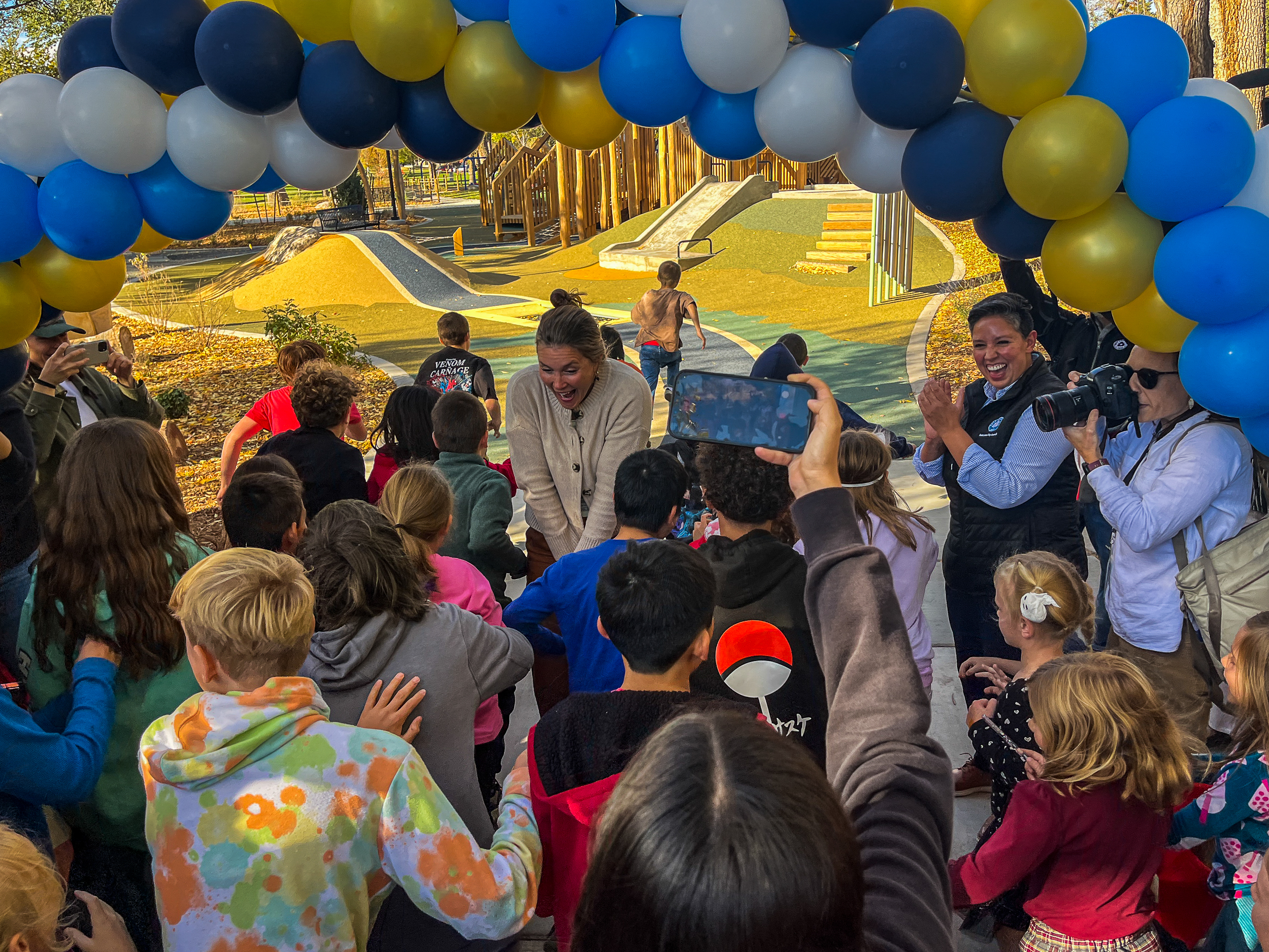 Children rush past Salt Lake City Mayor Erin Mendenhall to test out the Liberty Park’s new inclusive Rotary Play Park on Monday.