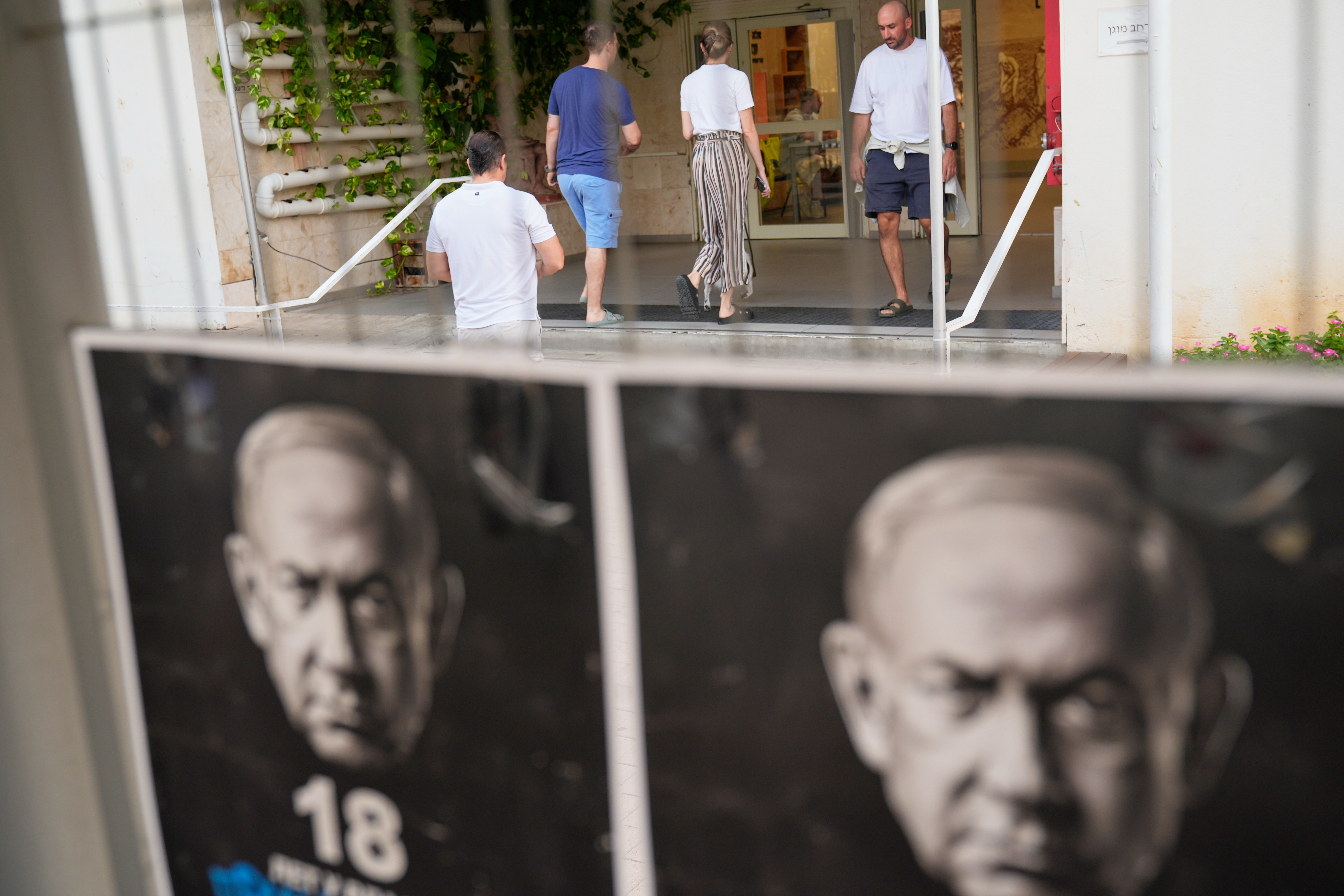 Voters arrive to cast their ballots in Israel's general election, in Tel Aviv, Tuesday. The pivotal election is taking place amid unresolved wars and divisions over Israel's future.