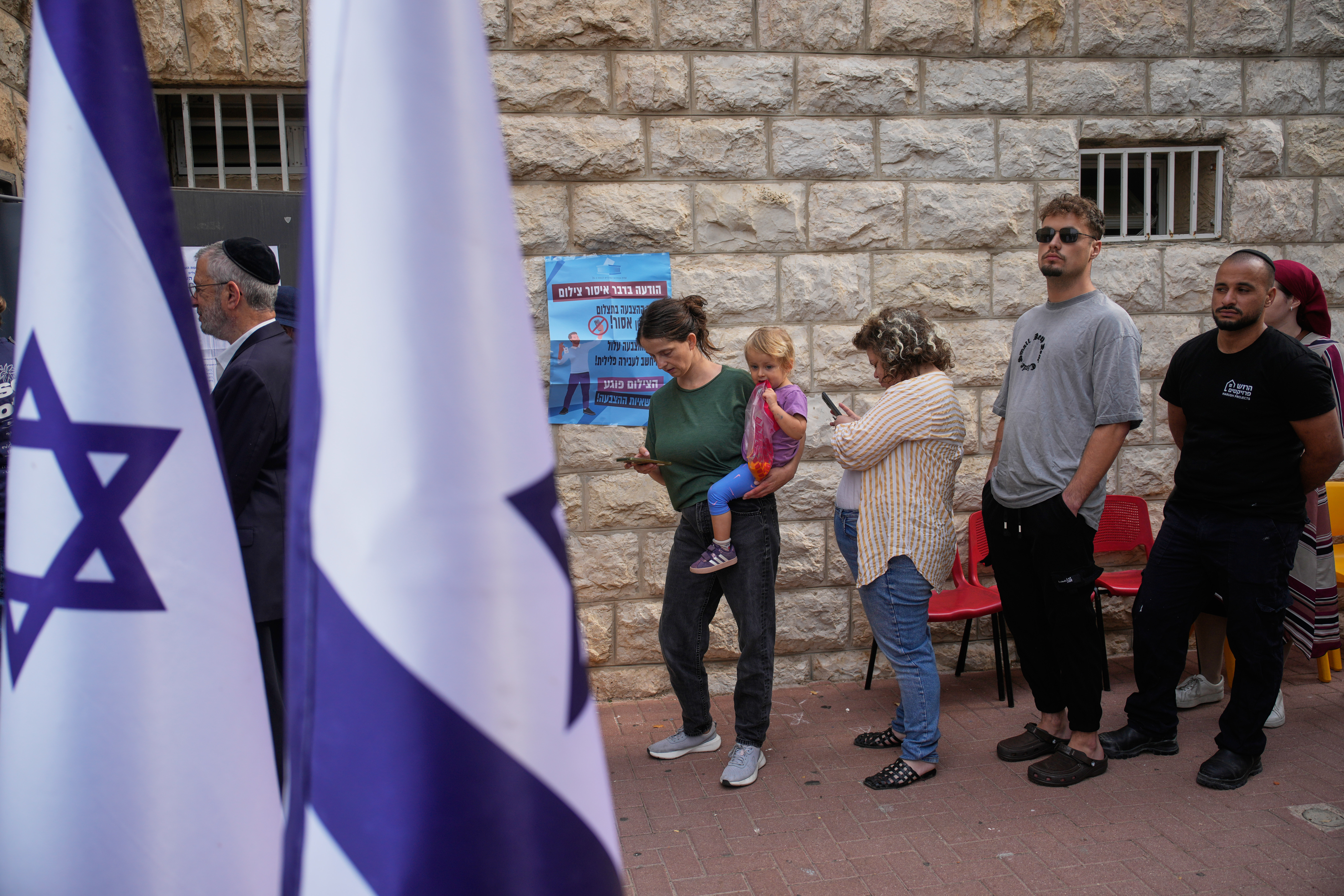 Voters line up to cast their ballots at a polling station during Israel's general election in Jerusalem on Tuesday. The pivotal election is taking place amid unresolved wars and divisions over Israel's future.