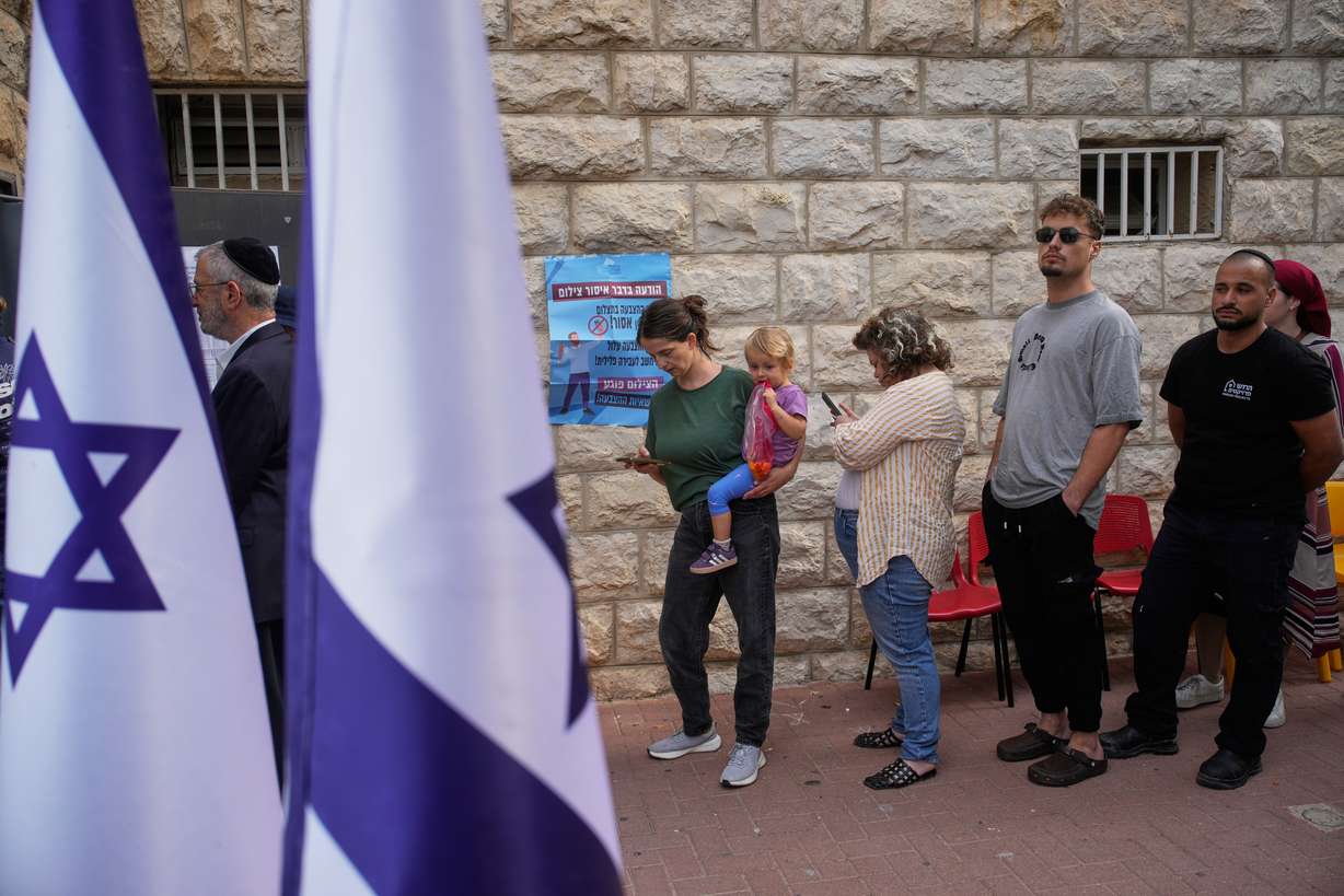 Voters line up to cast their ballots at a polling station during Israel's general election in Jerusalem on Tuesday. The pivotal election is taking place amid unresolved wars and divisions over Israel's future.
