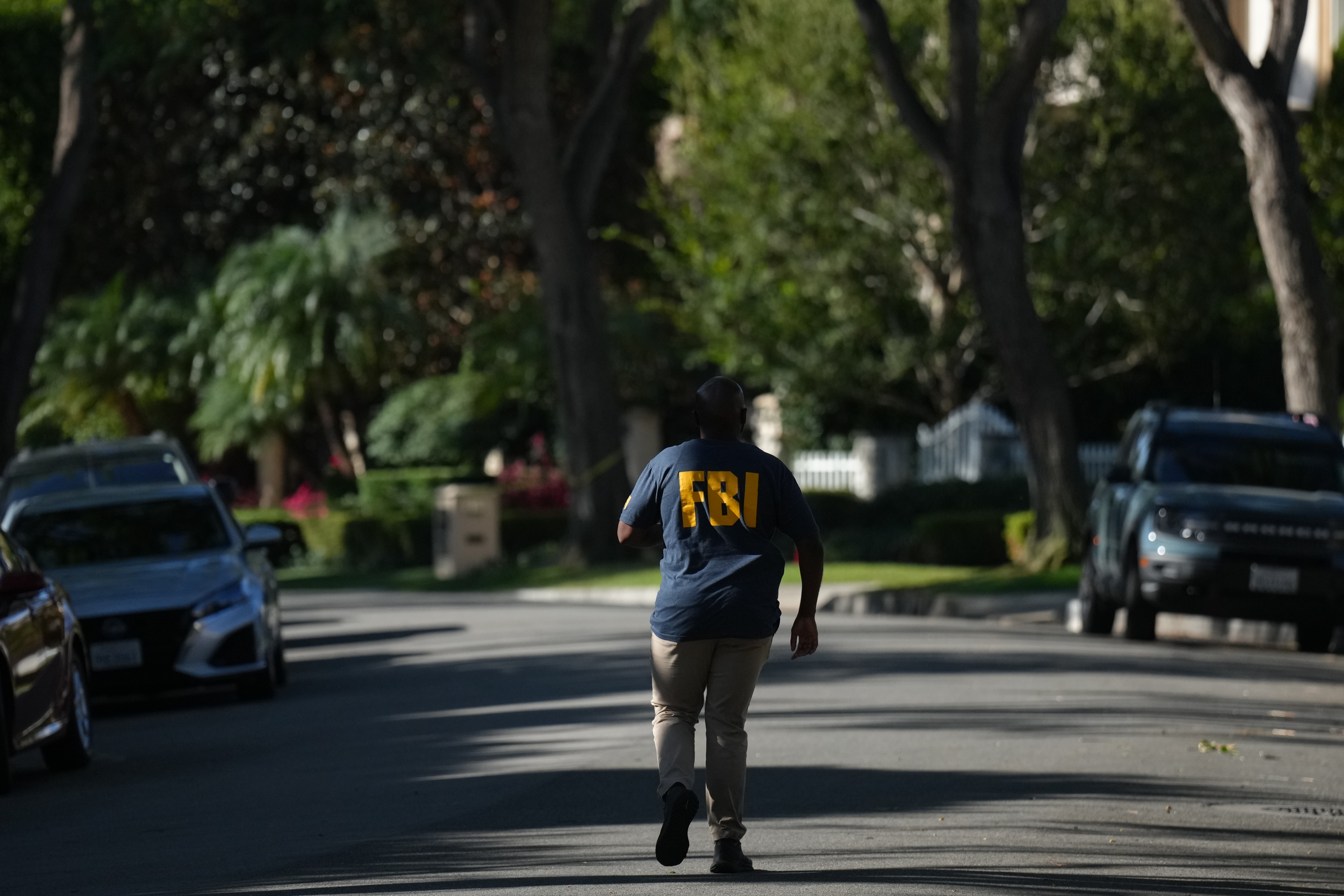 An FBI agent walks outside a home belonging to Stephen Cloobeck on Tuesday, in Beverly Hills, Calif. An FBI spokesperson said they would have no further comment on the reported search of the home.