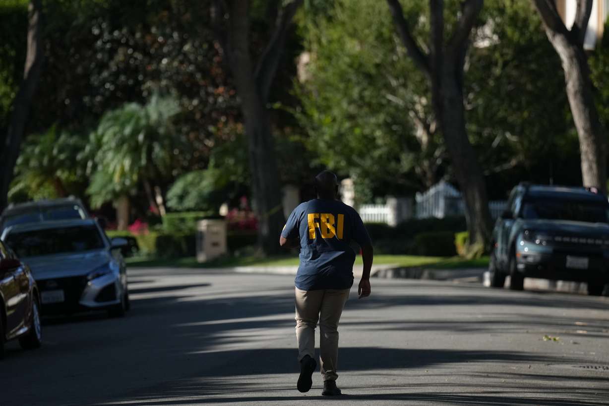 An FBI agent walks outside a home belonging to Stephen Cloobeck on Tuesday, in Beverly Hills, Calif. An FBI spokesperson said they would have no further comment on the reported search of the home.