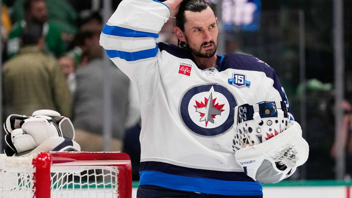 FILE - Winnipeg Jets goaltender Connor Hellebuyck stands by the net during a time out from play against the Dallas Stars in the first period of an NHL hockey game, April 2, 2026, in Dallas.