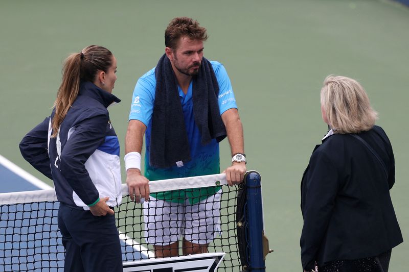 Switzerland's Stan Wawrinka speaks with the umpire and a court official during a rain delay in his first round match against Italy's Matteo Berrettini at Flushing Meadows, New York, United States - August 31, 2026. IMAGN IMAGES via Reuters/Amber