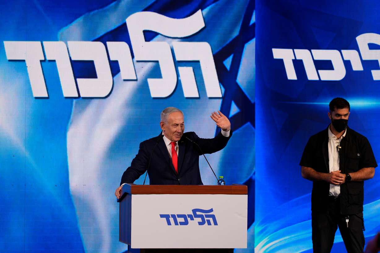 Israeli Prime Minister Benjamin Netanyahu waves to supporters at Likud party headquarters in Jerusalem following the release of the first exit poll results in Israel's general election, Wednesday. His party received 20.8% of the votes in the general election.