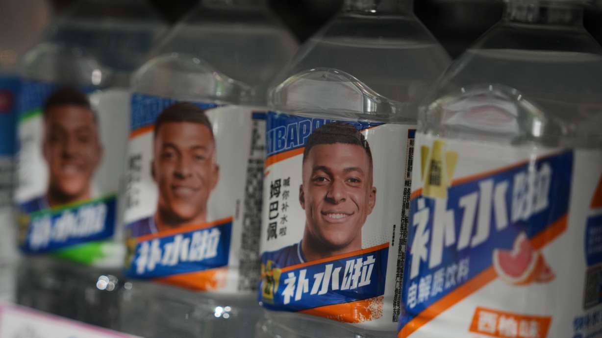 Bottles of electrolyte drink by Dongpeng Beverage Group featuring images of French soccer star Kylian Mbappé are displayed for sale at a supermarket in Beijing, Tuesday, Oct. 27, 2026.