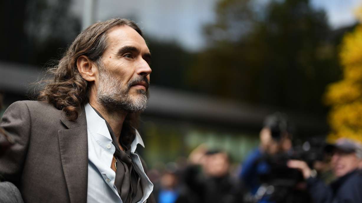Russell Brand arrives at Southwark Crown Court, London, Tuesday, where he faces three charges of rape, indecent assault, and three counts of sexual assault, relating to six women. Brand on Wednesday testified the charges have had a "devastating" impact on his life.