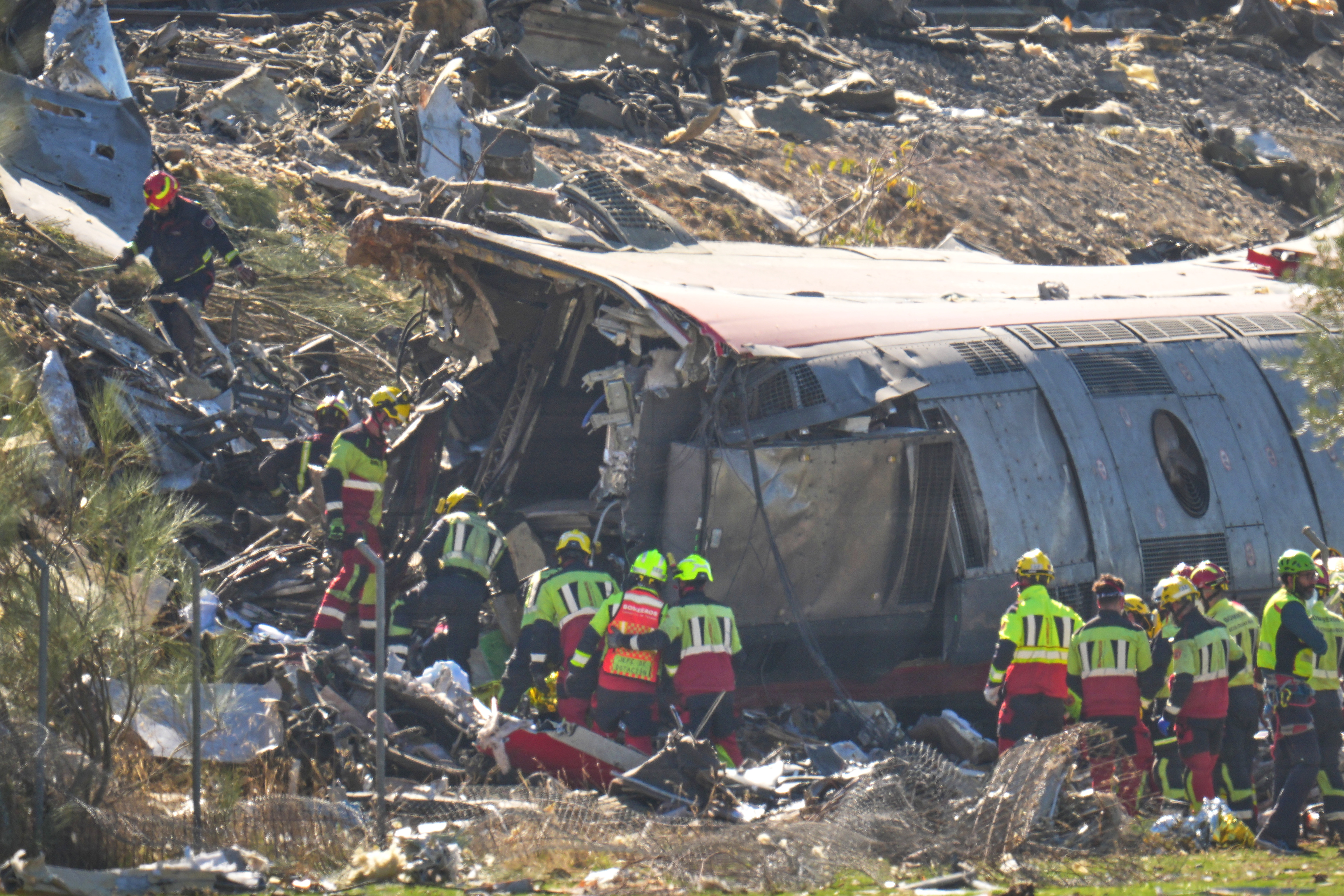 Emergency services work at the scene of a collision between two trains in Urda, Spain, Wednesday. Two cars were derailed, leading to at least 64 people being killed.