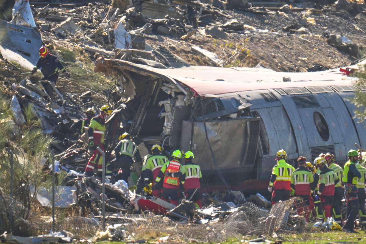 Emergency services work at the scene of a collision between two trains in Urda, Spain, Wednesday. Two cars were derailed, leading to at least 64 people being killed.