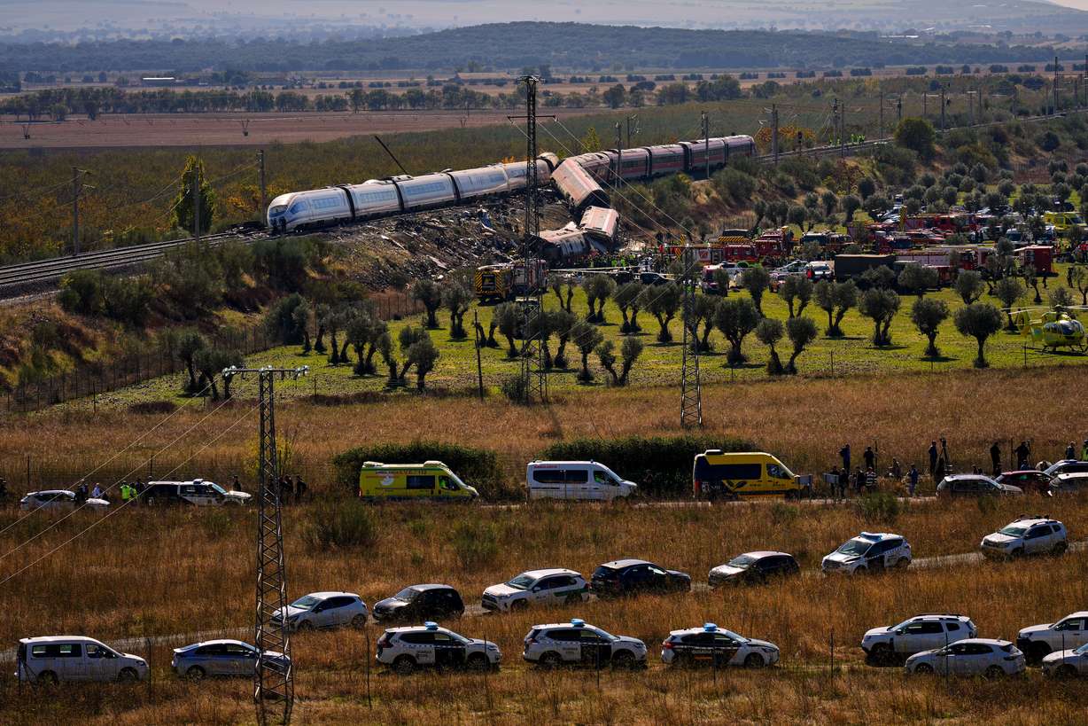 Emergency services work at the scene of a collision between two trains in Urda, Spain, Wednesday. Two cars were derailed, leading to at least 68 people being killed.