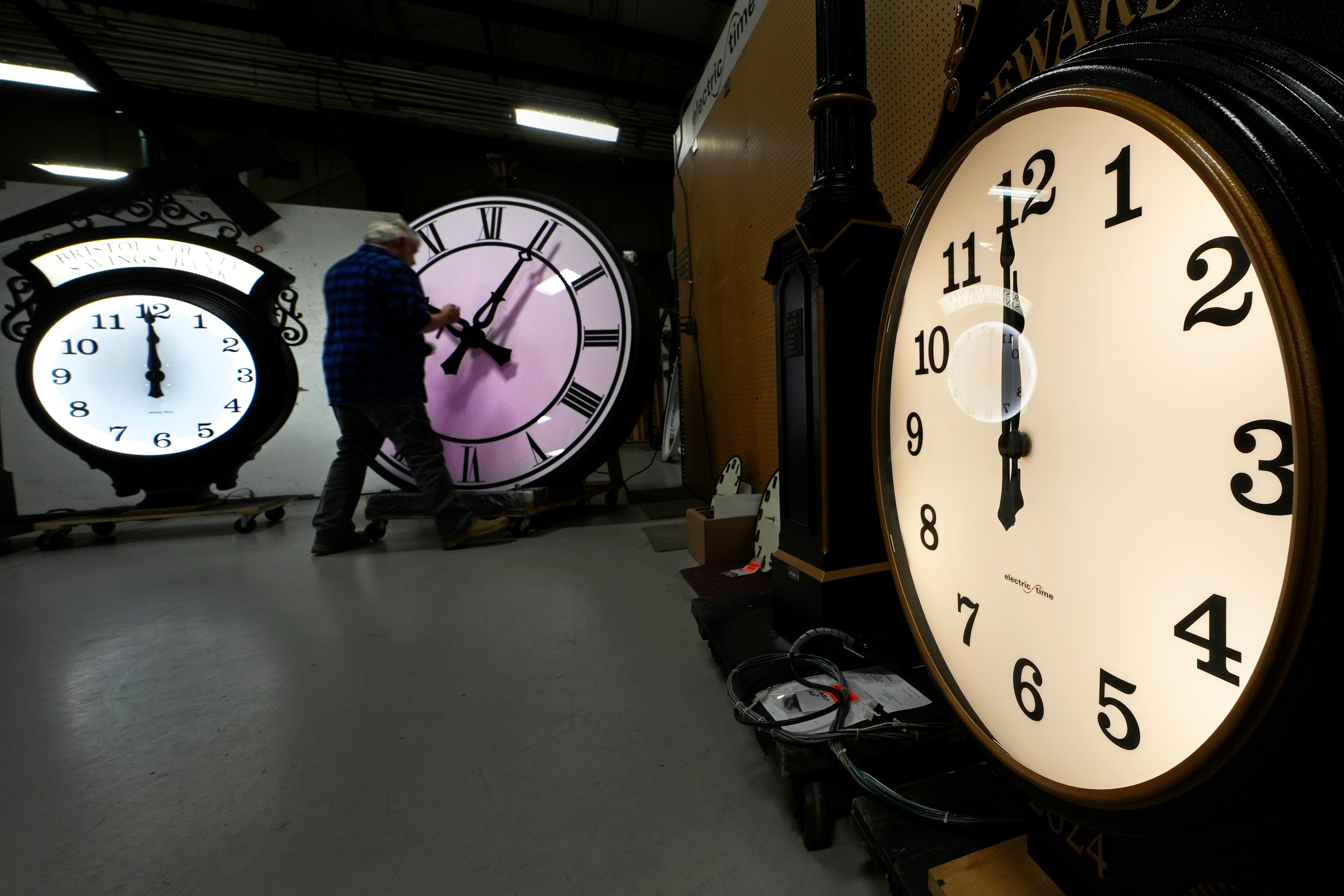 Clockmaker Scott Gow adjusts the hands of a clock at the Electric Time Company, Oct. 30, 2024, in Medfield, Mass. The Senate is unlikely to act on a House-passed bill to make daylight saving time permanent.