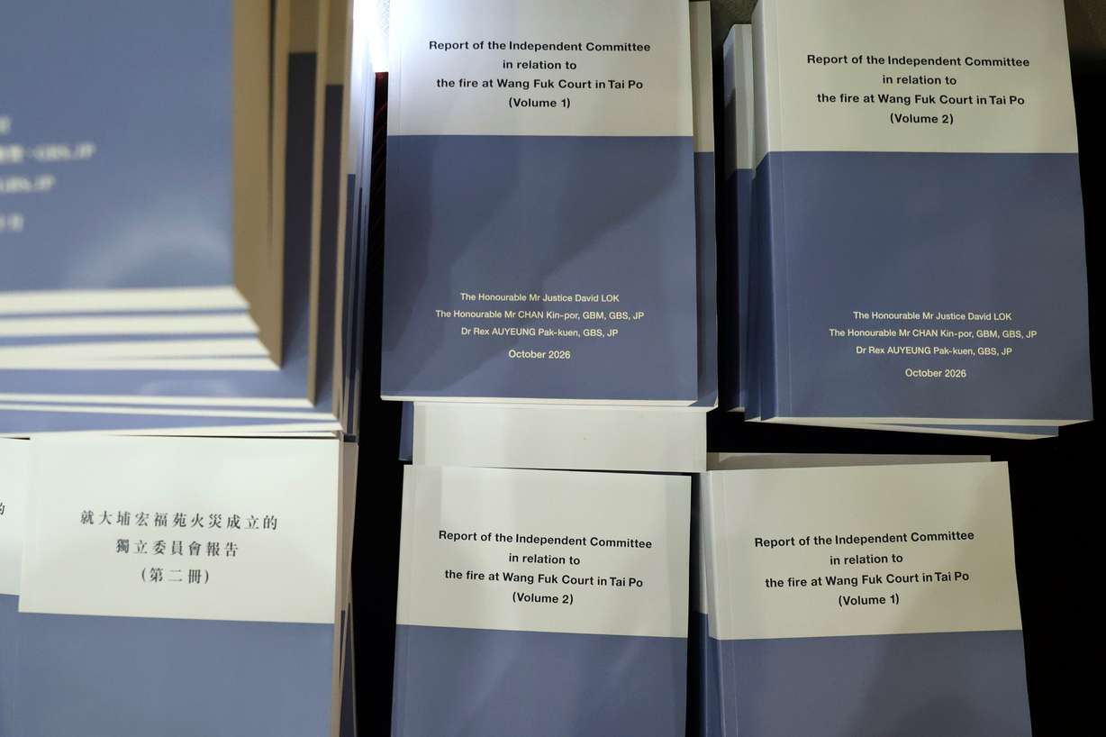 Copies of the Wang Fuk Court fire inquiry report are seen before a press conference in Hong Kong, Thursday. At least 168 were killed and thousands more were displaced in November's fire.