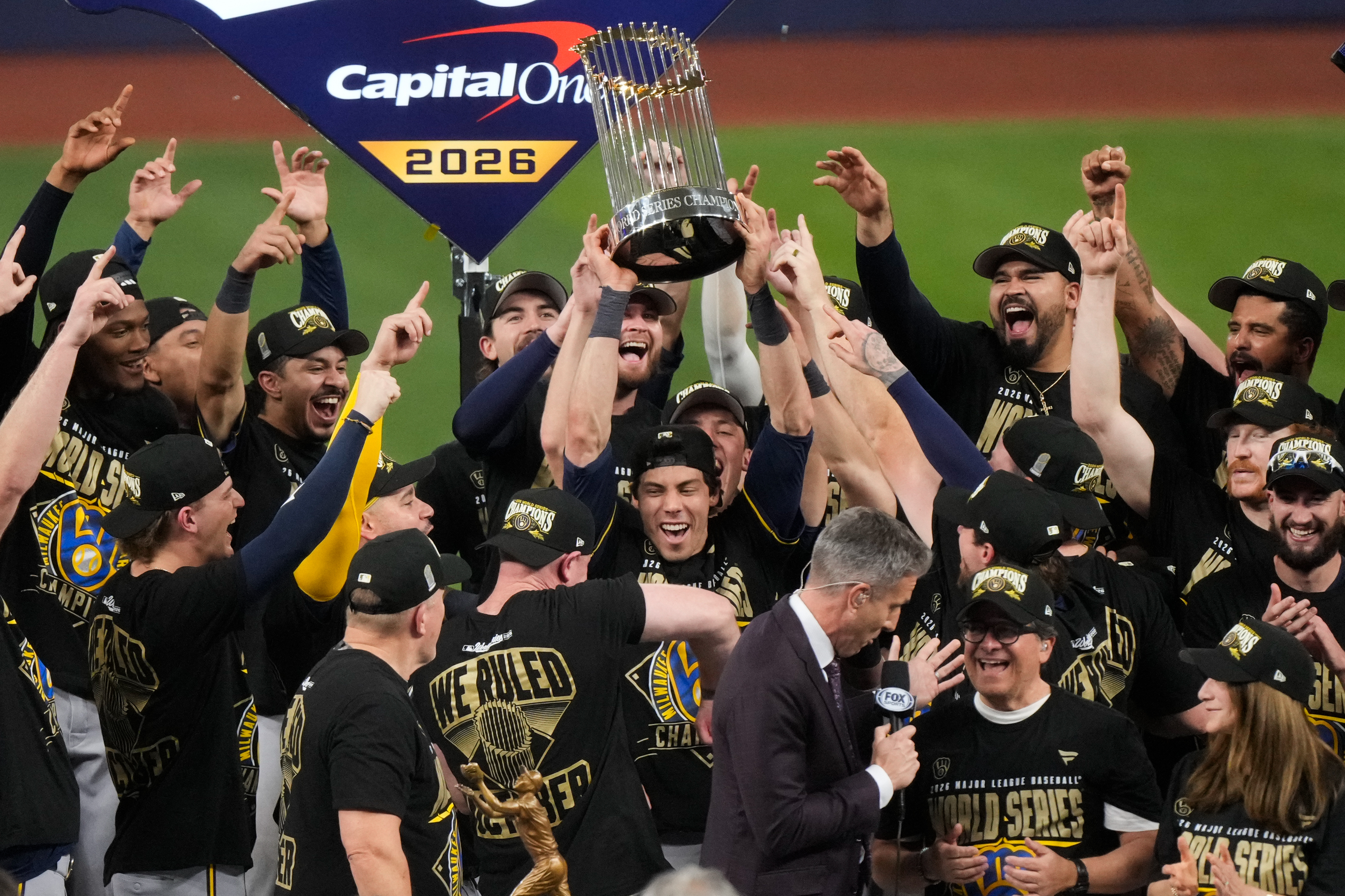 Milwaukee Brewers designated hitter Christian Yelich holds the World Series trophy with teammates after winning baseball's World Series, against the Tampa Bay Rays, Wednesday, Oct. 28, 2026, in St. Petersburg, Fla. 