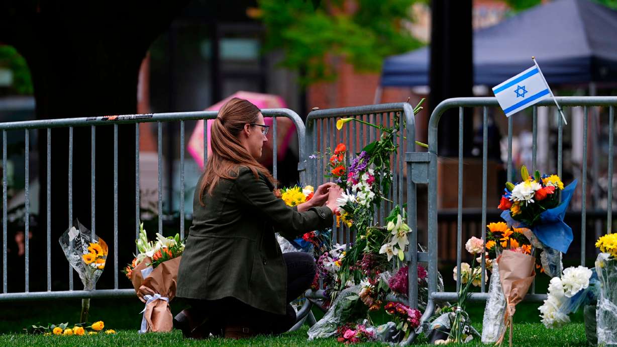 A woman places a bouquet of flowers at a makeshift memorial for victims of an attack outside of the Boulder County, Colo., courthouse, June 3, 2025. Mohamed Soliman pleaded guilty on Thursday to federal hate crimes in the attack.