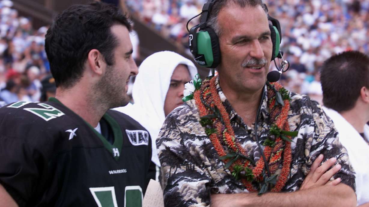 FILE - Hawaii coach June Jones and quarterback Nick Rolovich laugh during the fourth quarter action at Aloha Stadium in Honolulu on Dec. 8, 2001.