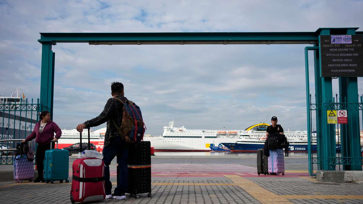 Passengers walk through the port of Piraeus during a 24-hour seafarers' strike over pay, working conditions and safety, alongside protests by port workers against the transport of military equipment through ports, near Athens, Greece, Friday.