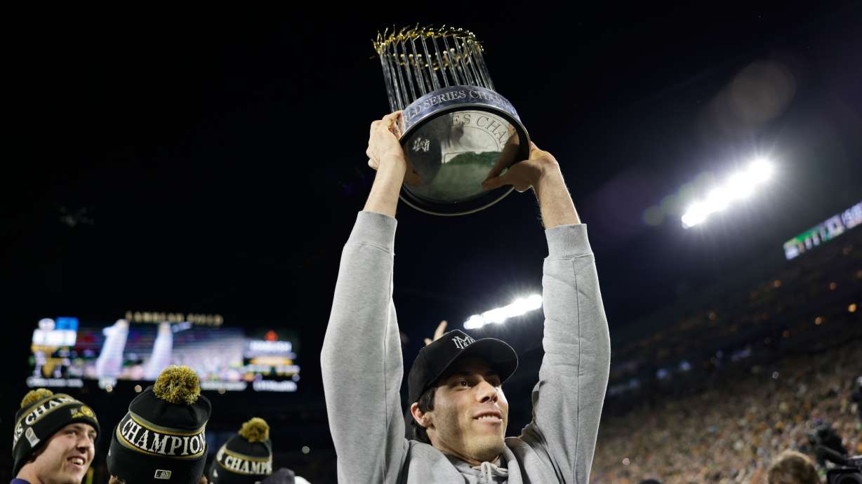 Milwaukee Brewers' Christian Yelich holds up the Commissioner's Trophy during the first half of an NFL football game between the Green Bay Packers and the Carolina Panthers in Green Bay, Wis., Thursday, Oct. 29, 2026.