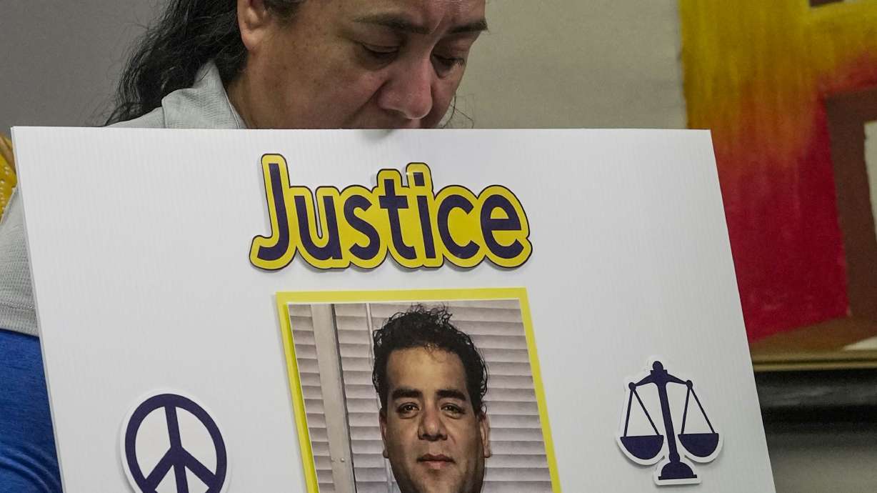 Carmen, sister of Miguel Parra Hernandez, holds a sign during a news conference about the Immigration and Customs Enforcement action involving Hernandez, Oct. 14, in Houston. A U.S. Immigration and Customs Enforcement officer accused of intentionally ramming his car into a Mexican construction worker in Houston has been charged with aggravated assault with a deadly weapon.