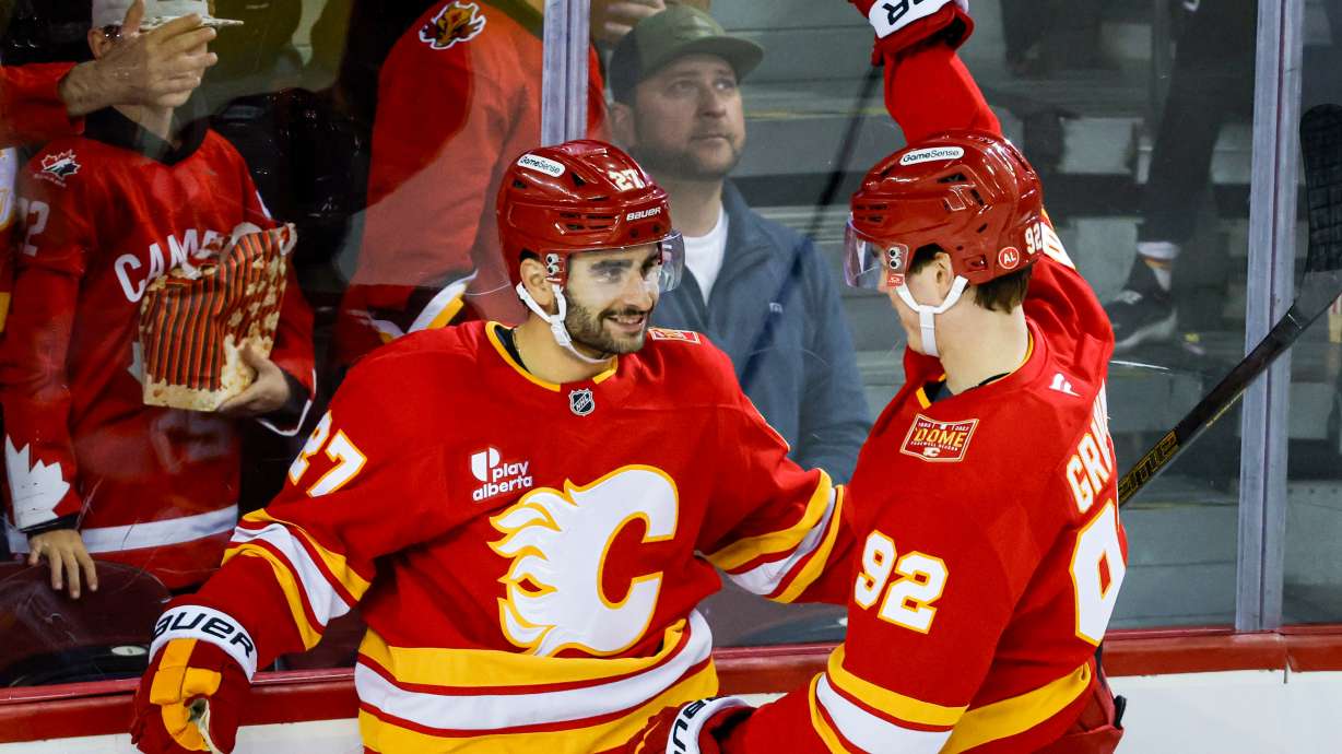 Calgary Flames' Matt Coronato, left, celebrates after his goal with teammate Matvei Gridin, right, during the third period of an NHL hockey game against the Seattle Kraken in Calgary, Alberta, Friday, Oct. 30, 2026.