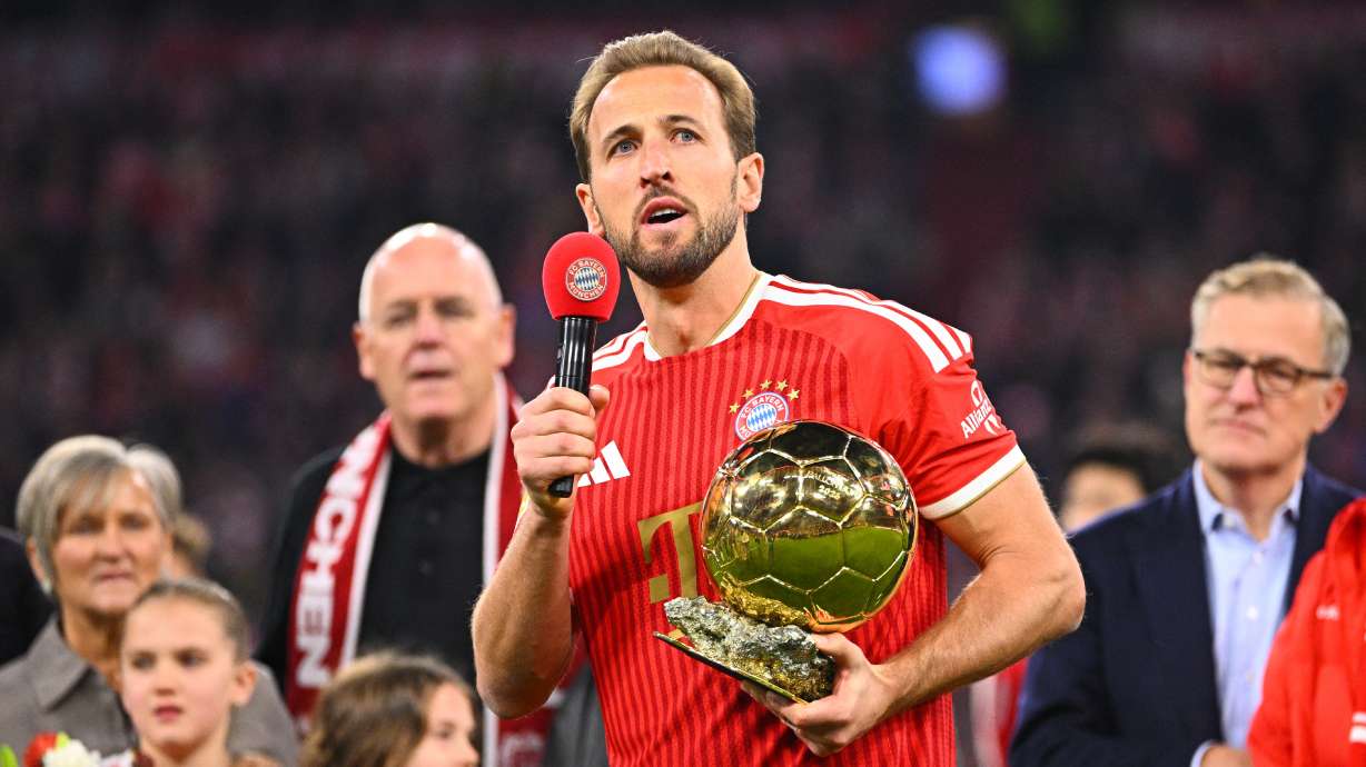 Munich's Harry Kane holds the 2026 Ballon d'Or trophy before the German Bundesliga soccer match between FC Bayern Munich and Borussia Dortmund in Munich, Germany, Saturday, Oct. 31, 2026.