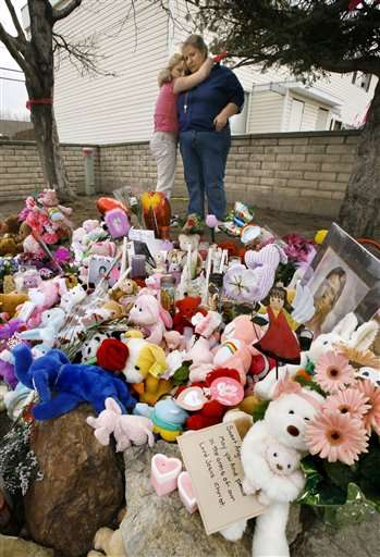 Kristina Smith and her daughter Rabecca hug next to a makeshift memorial outside the apartment complex of Hser Nay Moo on Wednesday, April; 2, 2008, in South Salt Lake, Utah. The 7-year-old's body was found Tuesday. (AP Photo/Douglas C. Pizac)