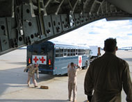 Military personnel prepare to unload patients into buses that will transport them to Walter Reed Army Medical Center and Naval Medical Center in Bethesda. The photo is taken from inside the C-17 aircraft. (Darci Marchese/WTOP Photo)