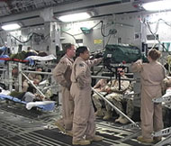 U.S. Air Force doctors and nurses wait to secure wounded military personnel in hospital beds in a C-17 aircraft. At left, men wounded in Iraq lie in stacked hospital beds waiting for the aircraft to takeoff from Iraq to Ramstein Air Force Base in Germany. (JJ Green/WTOP Photo)