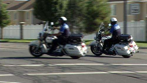 Police officers warn drivers to yield for pedestrians in crosswalks