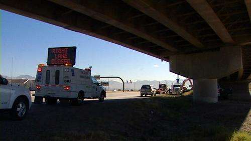 Truck hauling front-end loader hits overpass