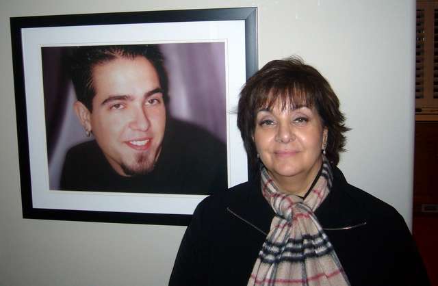 Sandra Kresser standing by a picture of her son Joshua