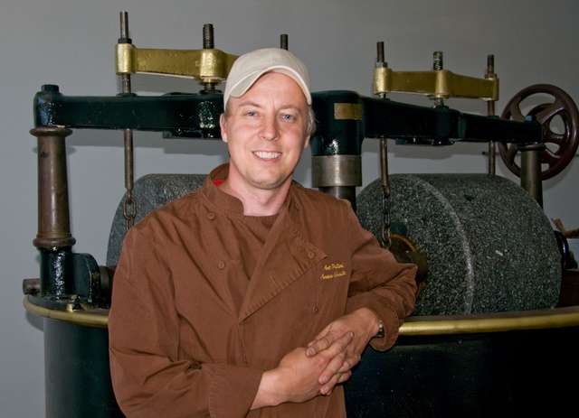 Art Pollard standing next to Amano's melangeur. Built in the late 20's early 30's in Germany by Bauermeister. Courtesy Amano Artisan Chocolate.